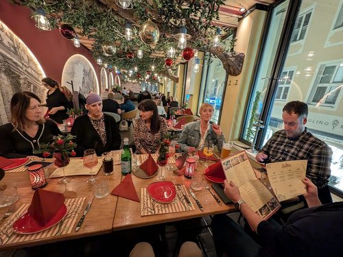 Team beim gemeinsamen Weihnachtsessen in einem festlich dekorierten Restaurant.