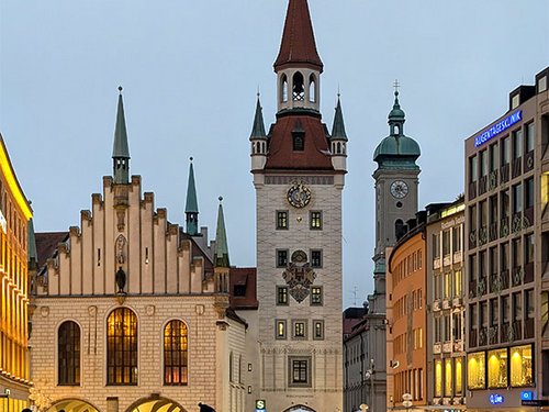 Altes Rathaus und Marienplatz in München bei Dämmerung mit Passanten.