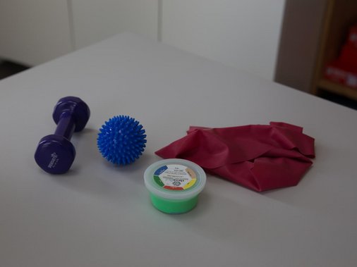 Kindertherapieraum mit Hängeschaukel, Spielzelt, Spiegel und Stühlen.