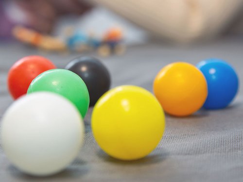 Sensorik-Übungen mit bunten Kugeln in der Bobath-Therapie.