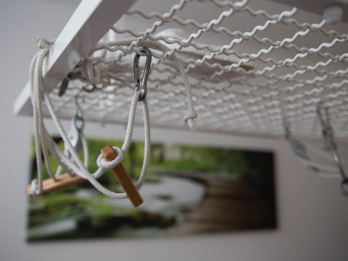 Mann trainiert an einem Zugapparat im Behandlungsraum, Tür mit Beschriftung „Gymnastik" im Hintergrund.
