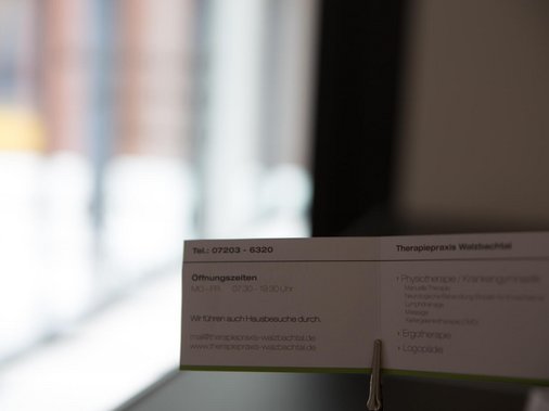Nahaufnahme der Klapp-Infokarte mit Kontaktdaten am Empfangstresen.