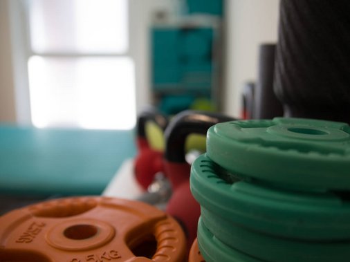 Nahaufnahme bunter Gewichtsscheiben und Kettlebells.