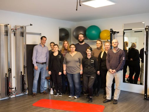Gruppenfoto des Praxisteams im Trainingsraum.